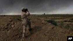 An Iraqi army member looks toward Islamic State group territory outside Qayyarah, Oct. 4, 2016. Qayyarah has become an important staging ground for military and humanitarian efforts ahead of the Mosul operation. 