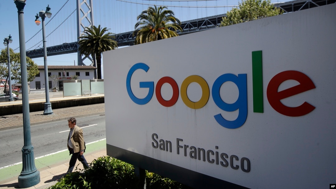 Seorang pria berjalan melewati papan iklan Google di San Francisco, 1 Mei 2019. 