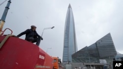 FILE - A worker sits on his water tank truck next to the business tower Lakhta Centre, the headquarters of Russian gas monopoly Gazprom in St. Petersburg, Russia, April 27, 2022. 