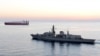 FILE - The British navy vessel HMS Montrose escorts a ship at sea off the coast of Cyprus, February 2014. The British navy said it intercepted an attempt, July 11, 2019, by three Iranian vessels to impede passage of a British commercial vessel.