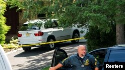 A law enforcement official is seen outside the home of federal judge Esther Salas, where her son was shot and killed and her defense attorney husband was critically injured, in North Brunswick, New Jersey, July 20, 2020.