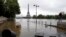 FILE - In this June 4, 2016, file photo, a woman, at right, takes photos of the flooded banks of the Seine in Paris. Scientists said at the time that man-made climate change had nearly doubled the likelihood of April 2016's devastating French flooding.