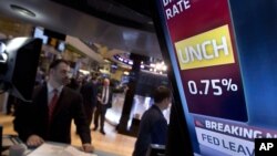 A television screen in a post on the floor of the New York Stock Exchange shows the decision of the Federal Reserve, January 30, 2013. 