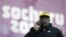 Winston Watts, the driver for JAM-1 of Jamaica, speaks on the phone after arriving at the sliding center during a training session for the men's two-man bobsled at the 2014 Winter Olympics, Wednesday, Feb. 5, 2014.