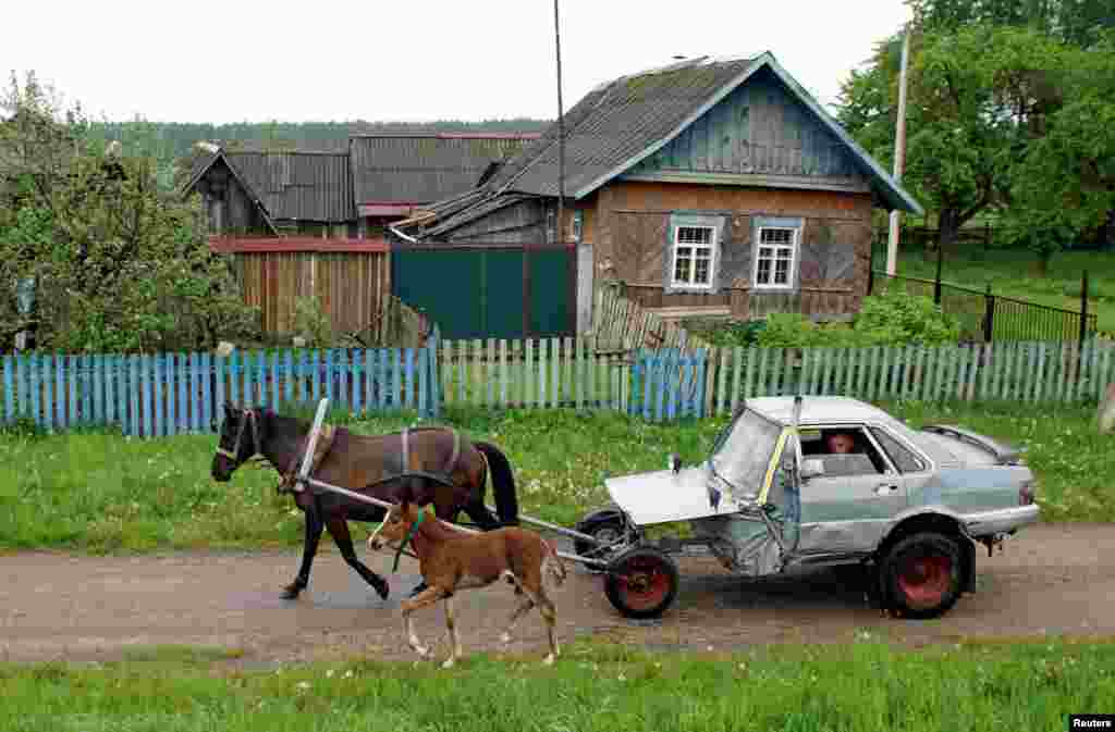Belarusian shepherd Alexey Usikov drives a horse-drawn carriage — equipped with a battery, head lights and small potbelly stove — which he crafted out of an old Audi-80, calling it jokingly Audi-40, in the village of Knyazhytsy.