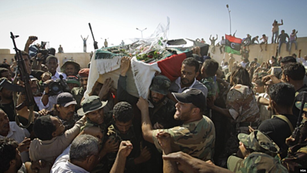 Para anggota pemberontak Libya mengangkat jenazah komandan militer, Abdel Fattah Younes dalam pemakaman di Benghazi (29/7).