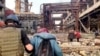 Arhiva - Pripadnik jedinice Azov pomaže ženi tokom evakutacije civila pod vođstvom Ujedinjenih nacija, iz železare Azovstal, nakon gotovo dvomesečne opsade koju su sprovodile ruske snage, tokom njihove invazije na Ukrajinu, u Marijupolju, Ukrajina, 1. maja 2022.
