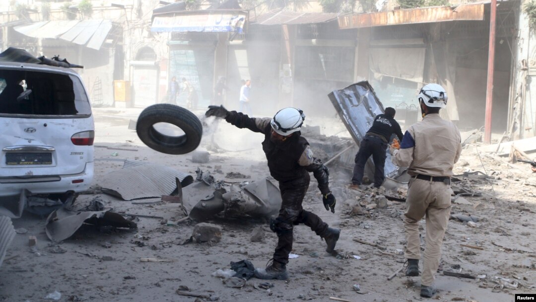 Para relawan mencari korban selamat pasca serangan udara Suriah terhadap posisi pemberontak di Aleppo (16/4).