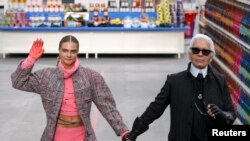 Desainer Jerman Karl Lagerfeld (kanan) dan model Cara Delevingne dalam peragaan busana pekan mode Paris, yang diadakan di "Pusat Perbelanjaan Chanel" (4/3). (Reuters/Benoit Tessier)