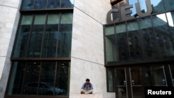 A man sits front of the building of the Central European University, a school founded by by U.S. financier George Soros, in Budapest, Hungary, April 9, 2018.