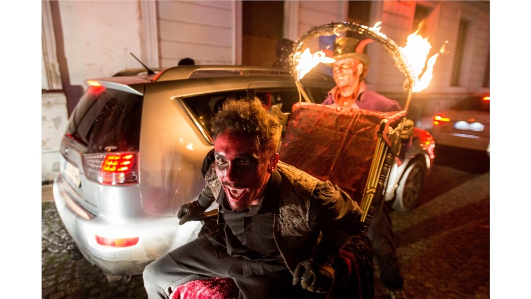Members of circus company Cirk La Putyka dressed as devils entertain people during their drive-through performance, Dec. 5, 2020, in Prague.