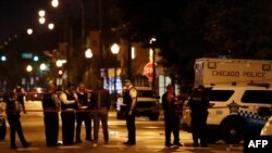 Police officers investigate at the scene of a shooting outside a funeral home in Chicago, Illinois, July 21, 2020.