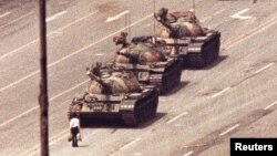 FILE - A man stands in front of a convoy of tanks in the Avenue of Eternal Peace in Beijing, China, June 5, 1989. 