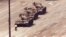 FILE - A man stands in front of a convoy of tanks in the Avenue of Eternal Peace in Beijing, China, June 5, 1989. 