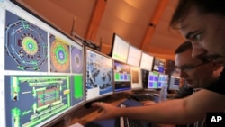 European scientists control computer screens showing traces on Atlas experiment of the first protons injected in the Large Hadron Collider (LHC) during its switch on operation at the Cern's press center on Wednesday, Sept. 10, 2008 near Geneva, Switzerland. 