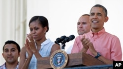 President Barack Obama and first lady Michelle Obama applaud during a Fourth of July celebration on the South Lawn of the White House, July 4, 2013. 