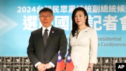 2024年1月12日，星期五，台湾台北，台湾民众党总统候选人柯文哲(左)与竞选伙伴吴欣盈在国际记者会上合影。（美联社）