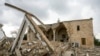 FILE - Georges Elia walks on the debris of the St. George Melkite Catholic Church, that was destroyed by Israeli airstrike, in the town of Dardghaya in southern Lebanon, Dec. 22, 2024. 