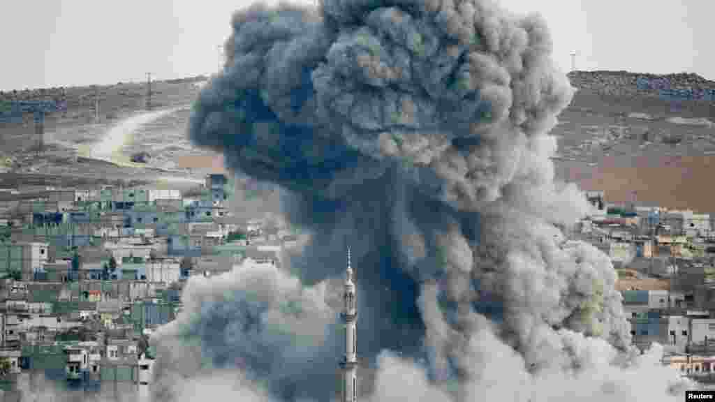 Smoke rises over Syrian town of Kobani after an airstrike, as seen from the Mursitpinar border crossing on the Turkish-Syrian border in the southeastern town of Suruc, Sanliurfa province, Oct. 18, 2014. 