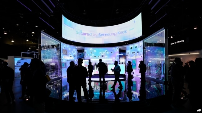 People look at a display of Samsung screens and products at the CES tech show Tuesday, Jan. 7, 2025, in Las Vegas. (AP Photo/Abbie Parr)