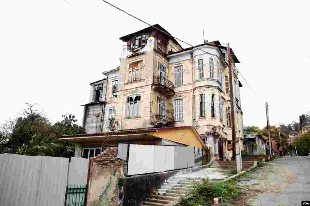 Rumah besar tepi bukit yang sudah kusam, dibangun dengan gaya Art Nouveau, memperlihatkan masa jaya Sukhumi sebagai kota pelabuhan dan sanatorium kesehatan jaman Czar Rusia.&nbsp;(V. Undritz/VOA)