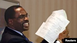 FILE - In this Jan. 29, 2004, file photo, former boxer, Rubin "Hurricane" Carter, holds up the document that freed him from prison, during a news conference held in Sacramento, California.