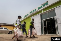 FILE—Volunteers take food supplies into the Lagos Food Bank warehouse in Lagos, Nigeria, March 23, 2024.