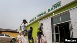 FILE—Volunteers take food supplies into the Lagos Food Bank warehouse in Lagos, Nigeria, March 23, 2024. 