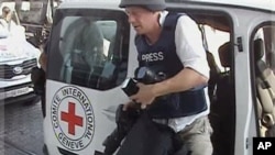 A journalist arrives at the Corinthia hotel after being evacuated from the Rixos Hotel in Tripoli in this image taken from TV Wednesday Aug. 24, 2011.