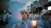 A woman holds a blue-colored cutout of the Korean Peninsula, symbolizing the unification of the two Koreas, during a candlelight vigil wishing for a successful summit between the U.S. and North Korea, in front of the U.S. embassy in Seoul, South Korea, June 9, 2018.