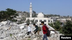 Boys walk amongst the rubble of the house of Palestinian assailant Ahmed Najeh Abu al-Rub after it was demolished by Israeli forces in the West Bank town of Qabatya near Jenin, April 4, 2016.