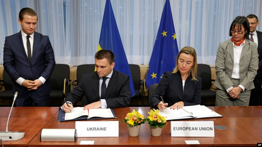 Menlu Ukraina Pavlo Klimkin (kiri) dan pejabat Uni Eropa Federica Mogherini menandatangani kesepakatan dalam pertemuan tingkat Menlu Uni Eropa di Brussels, Belgia, Senin (17/11).