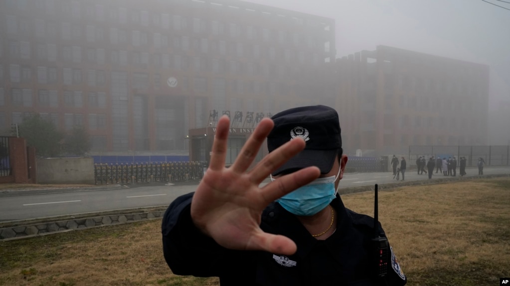 资料照片：世界卫生组织专家组抵达中国湖北省武汉市进行实地考察后，一名安保人员将记者从武汉病毒研究所附近驱离。(2021年2月3日)