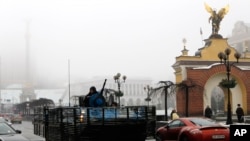 A Ukrainian military vehicle goes down the street on Independence Square in Kyiv, Ukraine, Jan. 23, 2015. 