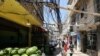 People walk along a street covered with electricity cables at Burj al-Barajneh refugee camp in Beirut