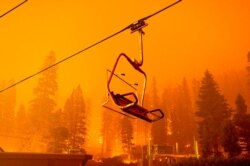 The Caldor Fire burns as a chairlift sits motionless at the Sierra-at-Tahoe ski resort in Eldorado National Forest, Calif., Aug. 29, 2021.