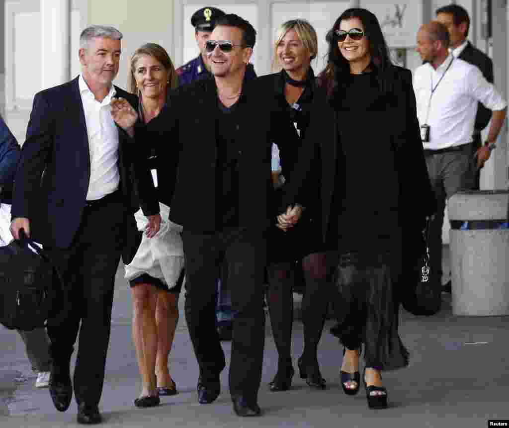 Irish singer Bono, lead singer of group U2, and his wife Ali Hewson arrive to take a taxi boat transporting guests for the wedding of U.S. actor George Clooney and his fiancee Amal Alamuddin, in Venice, Sept. 27, 2014. 