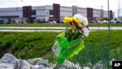 FILE - A single bouquet of flower sits in the rocks across the street from the FedEx facility in Indianapolis, April 17, 2021, where eight people were shot and killed. 