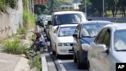 Conductores esperan junto a una fila de vehículos para entrar a una gasolinera en Caracas, Venezuela, el miércoles 30 de septiembre de 2020.