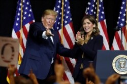 FILE - FILE- President Donald Trump and Governor Kristi Noem.