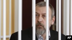 Former presidential candidate Andrei Sannikov sits in a cage during a court hearing in Minsk April 27, 2011.