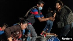 Asylum-seeking migrant families disembark an inflatable raft after crossing the Rio Grande river into the United States from Mexico in Roma, Texas, June 9, 2021.