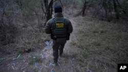 ARCHIVO: Un agente fronterizo camina por una senda llena de brazaletes usados por los traficantes de personas para el contrabando de migrantes hacia EEUU en McAllen, Texas, el 13 de febrero de 2025.