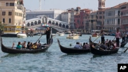 FILE - Tourists tour the Grand Canal on traditional Gondola Venetian boats, in Venice, Italy, Sept. 28, 2014. (AP Photo/Andrew Medichini)