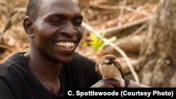 A Yao honey hunter holds a male Greater Honeyguide