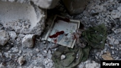 A bloodstained Syrian banknote is pictured at the site of a busy marketplace in the Douma neighborhood of Damascus. The market was hit by missiles Oct. 30, 2015. 