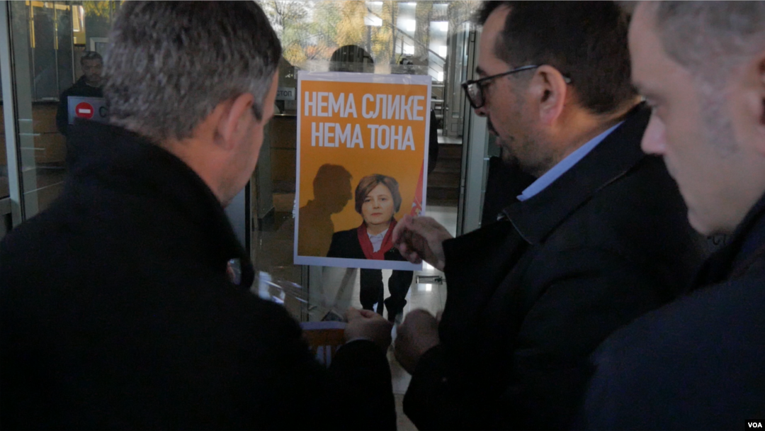Predstavnici opozicionog bloka Savez za Srbiju lepe plakat sa likom tužiteljke Zagorke Dolovac na ulaz Republičkog javnog tužilaštva, u Beogradu, 27. novembra 2019. (Foto: Rade Ranković, VOA)