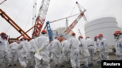 Karyawan Tokyo Electric Power Co. (TEPCO) dan pengunjung mengenakan masker dan pakaian pelindung saat meninjau PLTN Daiichi di Fukushima (Foto: dok). PLTN Sendai milik Kyushu Electric Power di selatan pulau Kyushu, Jepang, menjadi pembangkit nuklir Jepang yang pertama memulai kembali operasi di bawah standar yang lebih ketat.