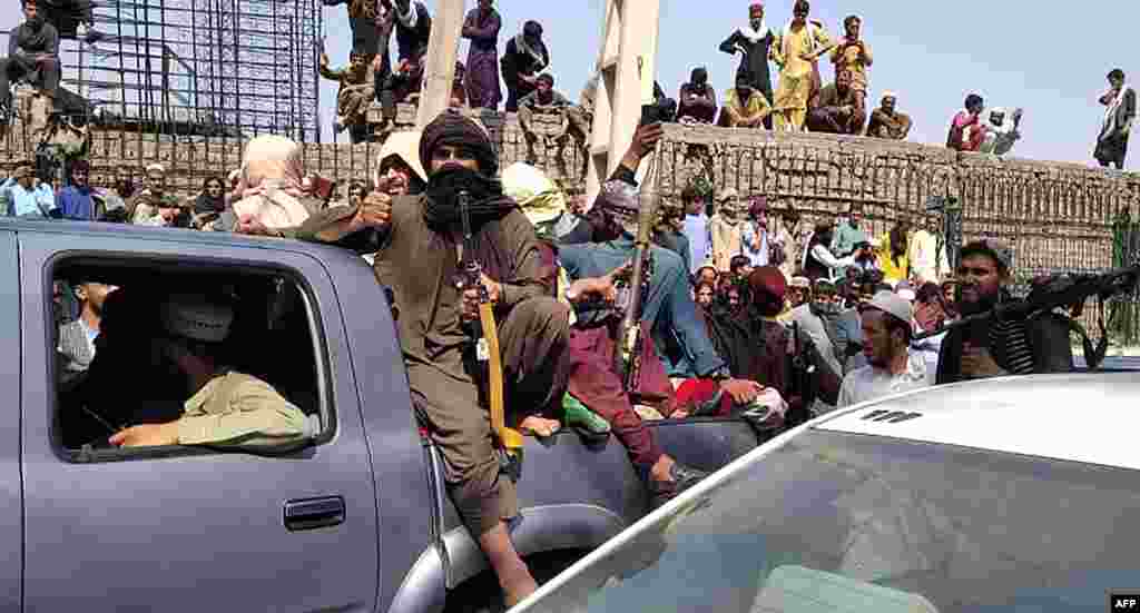 Taliban fighters sit on a vehicle along the street in Jalalabad province, Afghanistan.