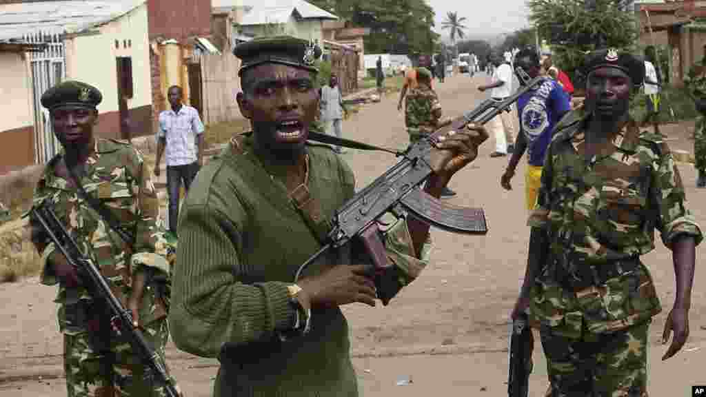 Des soldats tirent en l&#39;air pour disperser des manifestants qui ont acculé Jean Claude Niyonzima, un membre présumé de la milice Imbonerakure de la jeunesse du parti au pouvoir dans un égout dans le quartier de Cibitoke de Bujumbura, au Burundi, jeudi 7 mai 2015.